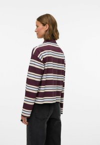 Gestreept longsleeve shirt in donker bordeauxrood, lichtblauw en crème. Zachte stof, ontspannen pasvorm, cropped ontwerp en zichtbare stiksel details.