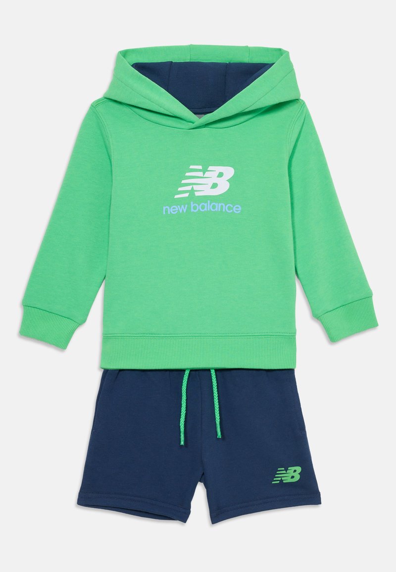 Felpa verde con accenti blu e logo "New Balance", abbinata a pantaloni corti blu navy. Tessuto morbido, polsini a coste e vita con cordino.