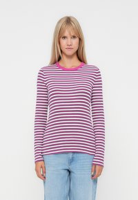 Långärmad randig skjorta i lila, vitt och rosa; har en rundad halsringning och en figurnära design. Mjuk tyg med en slät textur.