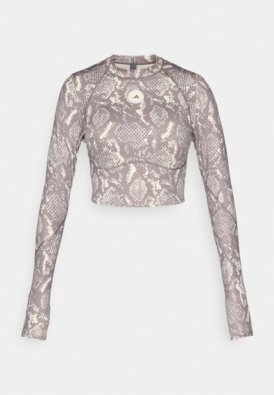Cropped long-sleeve top in a purple and cream snake pattern, featuring a round neckline and smooth stretchy material.