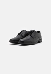 Black leather shoes with a smooth finish, round toe, and lace-up design. Features contrasting stitching and a low stacked heel.