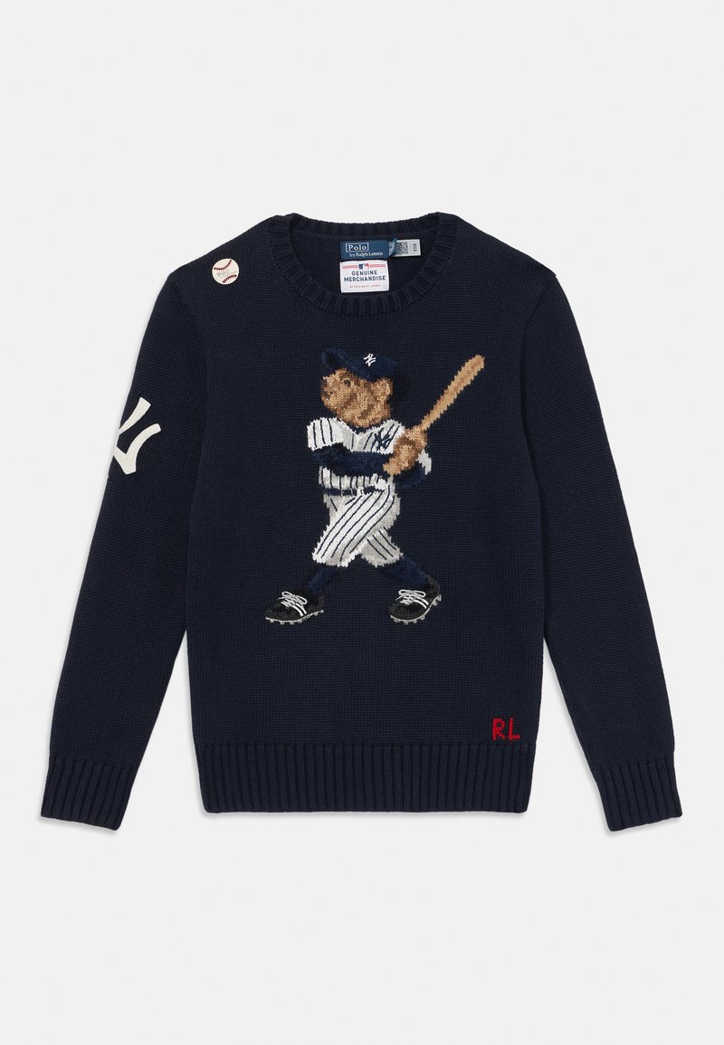 Marinblå stickad tröja med en broderad björn i basebollkläder, med randiga byxor och en klubba, samt en basebollnål på axeln.