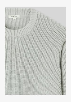 Pull en maille gris clair avec une texture côtelée et un col rond. Il a une coupe ample et une étiquette avec "BZB | LOOSE" visible.