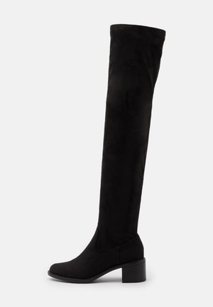 Bottes noires au-dessus du genou en daim, dotées d'un talon carré et d'une texture lisse, avec un design ajusté et sans éléments métalliques visibles.