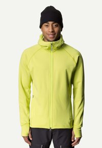 Bright yellow zip-up jacket with a high collar, made of soft fabric. Features raglan sleeves and a slim fit. Worn with a black knit beanie.