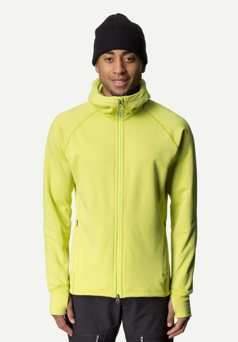 Bright yellow zip-up jacket with a high collar, made of soft fabric. Features raglan sleeves and a slim fit. Worn with a black knit beanie.