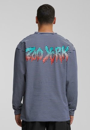 Long-sleeve striped shirt in navy and white, featuring a colorful "Zoo York" graphic on the back with a dripping paint effect.