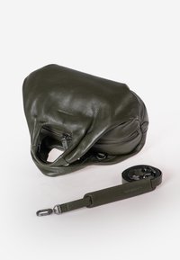 Olijfgroene leren handtas met textuurafwerking, ritssluiting en een verstelbare schouderband, met een ronde vorm en minimale details.
