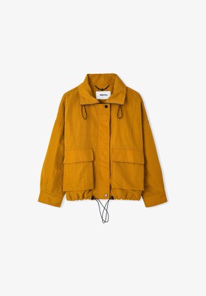 Senfgelbe Utility-Jacke mit großen Fronttaschen, Druckknöpfen, verstellbaren Kordelzügen an Saum und Kragen, langen Ärmeln und hohem Kragen.
