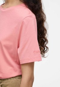 T-shirt a maniche corte in morbido cotone rosa, con un dettaglio ricamato "ROUGE" sulla manica e un classico scollo a girocollo.