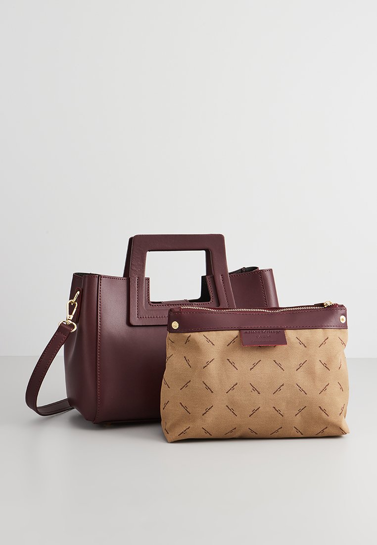 Sac à main en cuir bordeaux avec une poignée carrée, accompagné d'une pochette en toile beige ornée d'un motif en diamant subtil et de accents bordeaux.