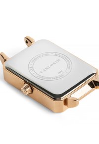 Boîtier de montre en acier inoxydable plaqué or avec un cadran argenté poli. Comprend une couronne texturée et un logo de marque gravé au dos.