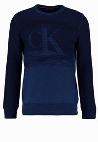 Mörkblå stickad tröja med rund halsringning. Har ett gradientmönster från mörk till ljus blå, samt en stor "CK" logotyp i mitten.