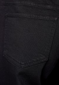 Mustassa denimmateriaalissa on takatasku, jossa on suorakulmainen muoto ja ommellut reunoja, näyttäen teksturoidun pinnan.