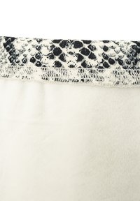 Weißer Stoff mit einer sanften Textur, versehen mit einem schwarz-weißen Schlangenmuster-Gummiband oben und sichtbaren Nähten entlang des Randes.