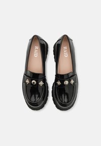 Loafers din piele patent neagră cu o talpă chunky. Prezintă embellismente metalice în față și un finisaj neted și lucios.