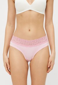 Rosa Baumwollslips mit einem floralen Spitzenbund, sorgen für eine glatte Textur und ein mittelhohes Design für hohen Komfort.