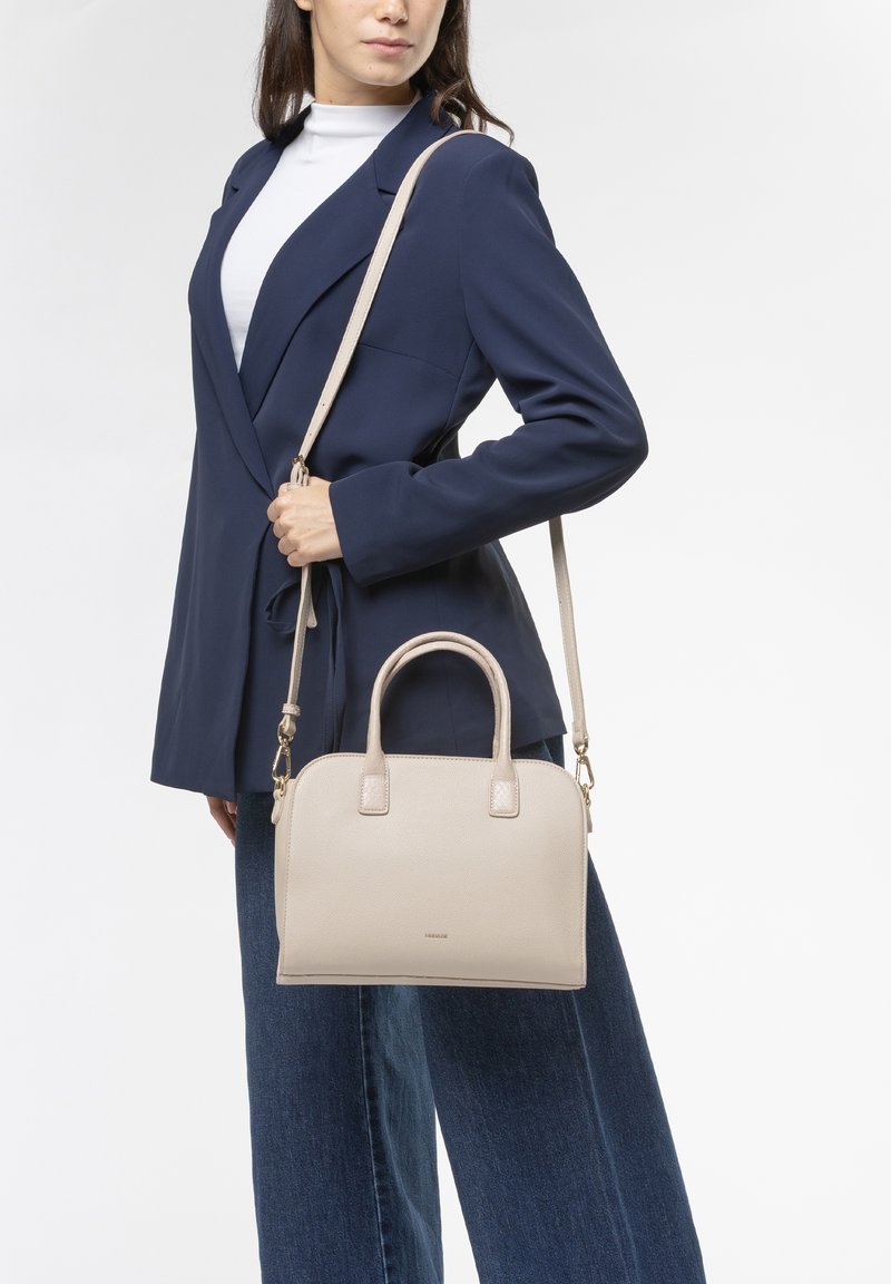 Bolso de cuero texturizado beige con asas dobles y una correa de hombro desmontable, forma rectangular y diseño minimalista, exhibido contra un fondo neutro.