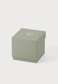 Boîte carrée en matériau vert clair texturé, avec un logo triangulaire doré sur le couvercle. Design épuré sans motifs supplémentaires.