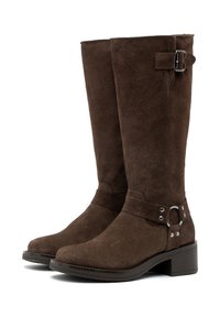 Botas altas de ante marrón a la altura de la rodilla con puntera cuadrada, acento de hebilla y un tacón bajo y cuadrado. Textura suave y minimalismo en los detalles de costura.