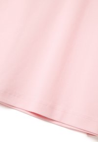 Camiseta de algodón de color rosa claro con una textura suave, mangas cortas y un dobladillo recto. Sin patrones visibles ni detalles metálicos.