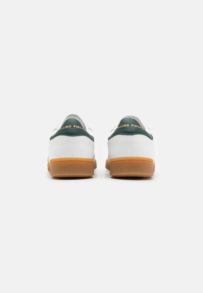 White leather sneakers with green accents and golden logo. Rubber gum sole. Smooth texture, rounded shape, visible stitching details.