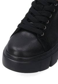 Schwarzer Sneaker mit einem Obermaterial aus glattem Leder und Wildleder, runder Zehenpartie und dickem Plateausohlen. Ausgestattet mit schwarzen Schnürsenkeln und metallicfarbigen Ösen.