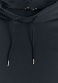 Felpa grigia scura realizzata in tessuto morbido, con cappuccio regolabile con punte metalliche e un design semplice e pulito. Assente di motivi o grafiche.