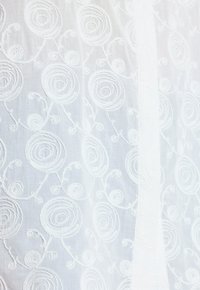 Hvidt stof med broderede, cirkulære blomsterhemmeldninger og snoede vintagedetaljer, der viser tekstur og fint syning.