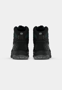 Czarne i zielone wysokie buty trekkingowe z teksturowaną cholewką, wzmocnionym piętą i solidną gumową podeszwą. Zawiera logo oraz wodoodporny design.