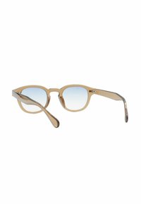 Occhiali da sole con una montatura trasparente beige, lenti blu sfumate e dettagli in argento sulle aste, con una forma rotonda e braccia curve.