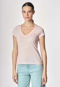 T-shirt in cotone rosa con scollo a V e maniche corte, caratterizzata da un piccolo logo ricamato sul petto. Tessuto morbido, vestibilità slim, design leggero.
