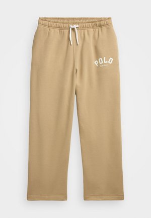 Beżowe spodnie dresowe z elastycznym pasem, białym sznurkiem i białym logo "POLO Ralph Lauren" na lewej udzie.