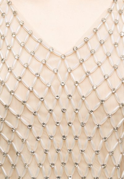 Ύφασμα από κρεμ δίχτυ διακοσμημένο με πλέγμα σε σχήμα ρόμβου από λευκές χάντρες και διάφανα στρας στην περιοχή της γραμμής του λαιμού.