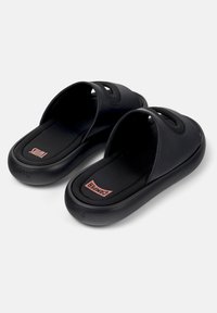 Zwarte instapsandalen met dikke, gevoerde zolen, brede banden met uitsnijdingen en het rode Camper-logo op de voetbedden.