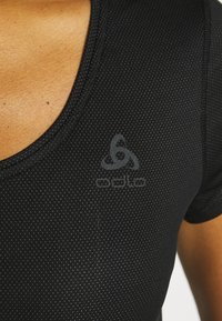 Black athletic shirt with a v-neck design, made from breathable mesh material, featuring a subtle logo printed on the chest.