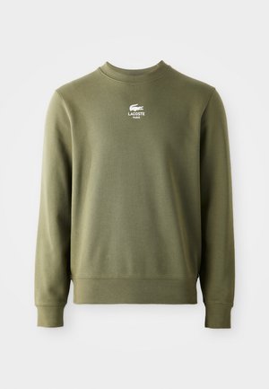 Olijfgroene trui met lange mouwen en ronde hals met wit Lacoste Paris-logo en krokodillembleem gecentreerd op de borst.