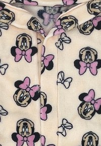 Lichtroze fleece stof met een patroon van cartoongezichten met zwarte oren en roze strikken, verfraaid met kleine witte vlinders.