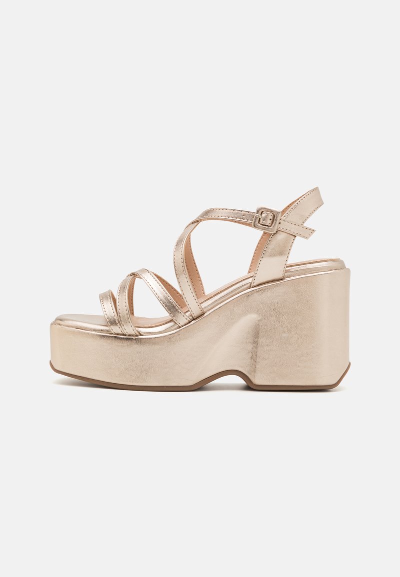 Sandali platform in oro metallico con cinturini esposti, un tacco largo e una superficie texturizzata. Cinturino alla caviglia regolabile per una vestibilità sicura.