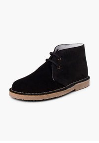Botas de ante negras hasta el tobillo con punta redondeada, diseño de cordones y suela de goma marrón claro en contraste. Presenta acentos de costura visibles.