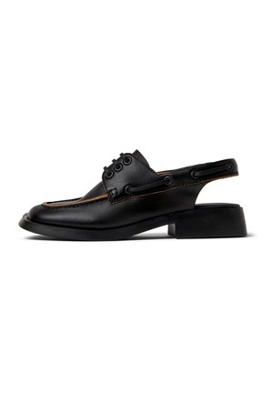 Mocassin à bride arrière en cuir noir avec petit talon bloc, couture moc toe, détail lacé, et bride arrière ouverte sur fond blanc.