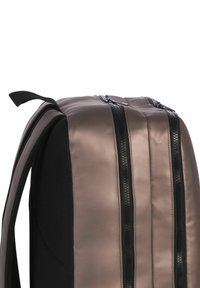 Schwarz-brauner Rucksack mit einer glatten, glänzenden Oberfläche, Netzakzenten, zwei schwarzen Reißverschlüssen und gepolsterten Schultergurten für zusätzlichen Komfort.