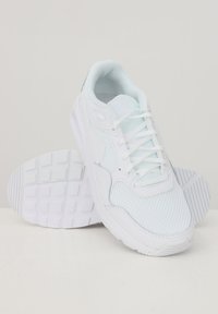 Zapatillas deportivas blancas con parte superior de malla, suela de goma sólida y cordones planos. El diseño incluye un logotipo discreto y un cuello acolchado.