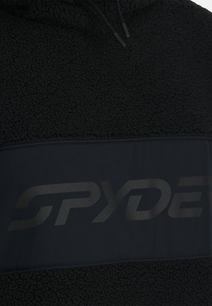 Pullover in pile nero con una finitura testurizzata e una fascia nera uniforme che presenta un grande logo Spyder in una finitura opaca sottile.