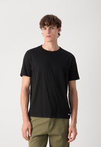 Black short-sleeve t-shirt made of cotton, featuring a classic crew neckline, relaxed fit, and subtle logo at the bottom left hem.