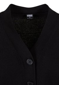 Čierny kardigán s výstrihom do V, pletenou látkou a dvoma čiernymi gombíkmi vpredu. Na štítku je nápis „Urban Classics“ s veľkosťou XS.