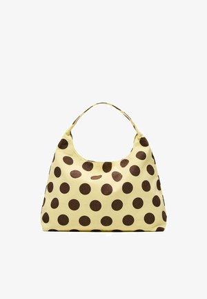 Keltäinen käsilaukku, jossa isot ruskeat pilkulliset täplät, pehmeä kangas ja yksinkertainen hihnakahva.