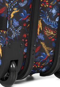 Hårdkapslad resväska med ett svart blommönster i rött, blått och gult. Har svarta hjul och ett texturerat handtag.