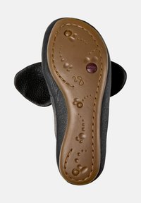 Zapato de cuero negro con parte superior texturizada y suela de goma marrón, que presenta un patrón en relieve y un detalle de logo circular.