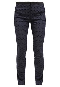 Pantalon bleu marine à coupe ajustée, avec un motif discret de pois noirs et une texture lisse. Comporte une ceinture noire.